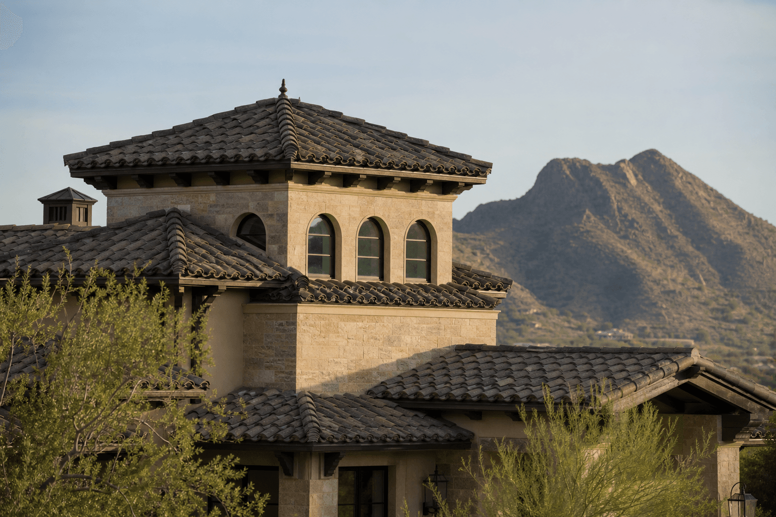 A Paradise Valley estate at dawn — single-story mid-century modern architecture with low-pitched standing seam metal and integrated tile, framed by the Mummy Mountain range.